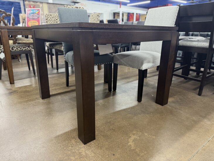 Expandable espresso wood dining table with square-to-large-square transformation.